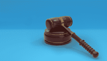 A gavel on against a blue background
